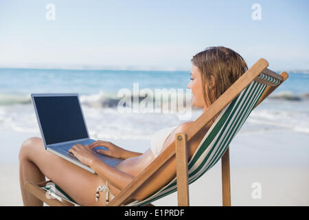 Frau entspannen im Liegestuhl am Strand mit laptop Stockfoto