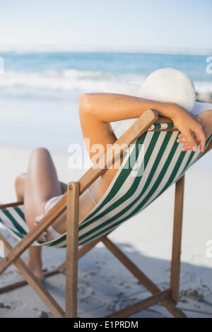 Schlanke Frau entspannen im Liegestuhl am Strand Stockfoto