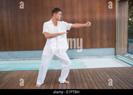 Gut aussehender Mann in weiß Tai Chi zu tun Stockfoto