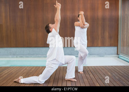 Friedliche paar in weiß tun Yoga zusammen Stockfoto