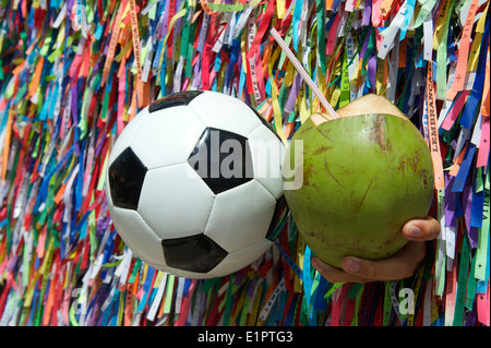 Brasilianische Kultur mit Fußball Fußball und frische grüne Coco Gelado Kokosnuss an Wand des Wunsch-Bänder in Salvador Bahia Brasilien Stockfoto