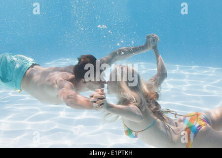 Süßes Paar küssen unter Wasser im Schwimmbad Stockfoto