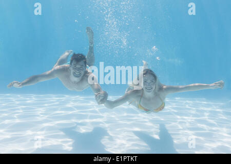 Süßes Paar lächelnd in die Kamera unter Wasser im Schwimmbad Stockfoto