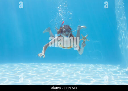 Süße Blonde unter Wasser im Schwimmbad mit Schnorchel und Seestern Stockfoto