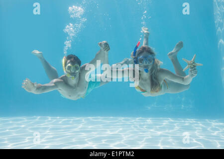 Süßes Paar unter Wasser im Schwimmbad mit Schnorchel und Seestern Stockfoto