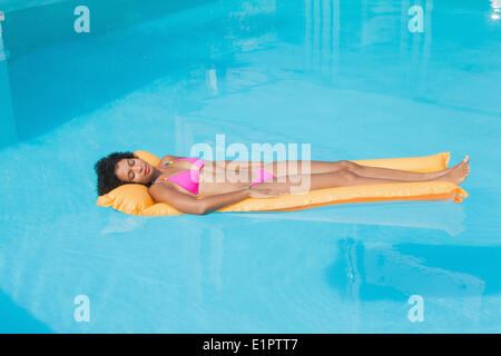 Fit Frau liegt auf Lilo im Schwimmbad Stockfoto