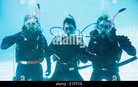 Freunde auf Tauchausbildung untergetaucht im Schwimmbad machen ok Sign. Stockfoto