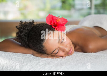 Wunderschöne Frau, die auf Massagetisch liegend mit Salz Behandlung auf Rückseite Stockfoto