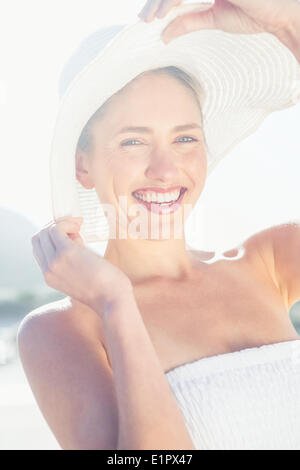 Hübsche Blondine im weißen Kleid und Sonnenhut am Strand Stockfoto