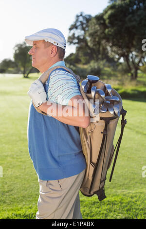 Golfer stehen hält seine Golf-Bag Stockfoto