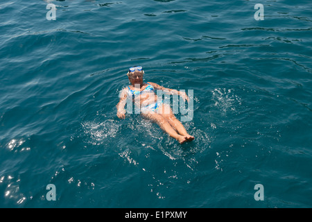 Hohen Winkel anzeigen Alter Frau, dass Schwimmen auf dem Rücken in das Meer. Stockfoto