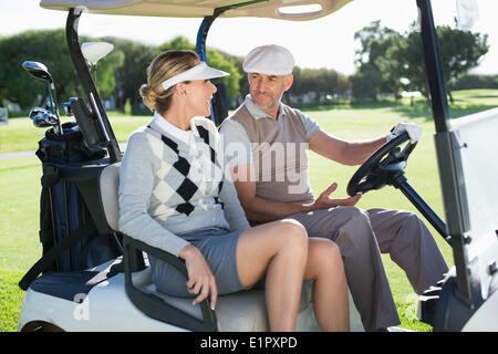 Golf Brautpaar sitzen im Buggy Lächeln einander an Stockfoto