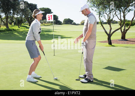 Lady Golfer auf dem Putting-Green am 18. Loch mit partner Stockfoto