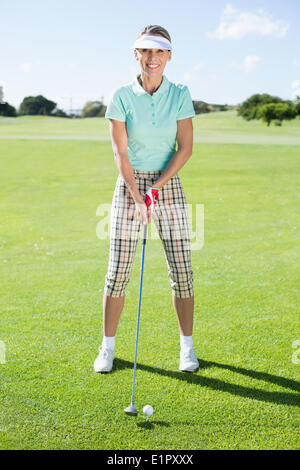 Lady Golfer Abschlag für den Tag lächelnd in die Kamera Stockfoto