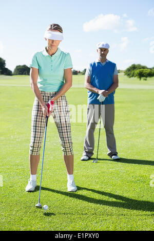 Lady Golfer Abschlag für den Tag beobachtet von partner Stockfoto