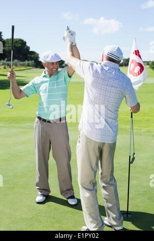 Golf Freunde hohe Fiving am 18. Loch Stockfoto