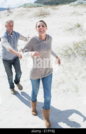 Attraktives Paar spielen am Strand jagen Stockfoto