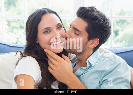 Attraktives Paar auf der Couch kuscheln Stockfoto