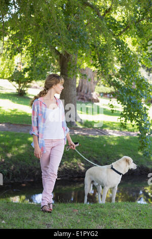 Süße Blonde mit ihrem Labrador Hund im park Stockfoto