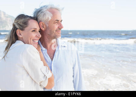 Glückliches Paar umarmt am Strand, Blick auf das Meer Stockfoto