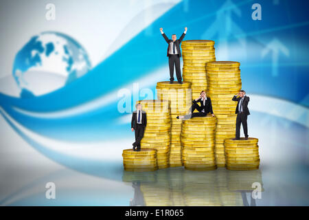 Zusammengesetztes Bild von Geschäftsleuten auf Haufen von Münzen Stockfoto