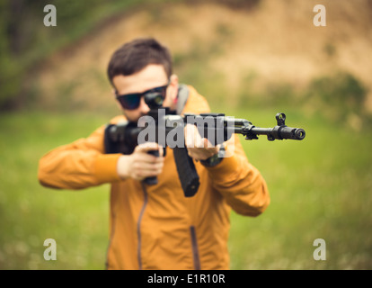 Ein Mann mit einem automatischen Gewehr im freien Stockfoto