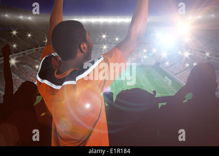 Zusammengesetztes Bild von jubelnden Fußballfan in Jersey orange Stockfoto