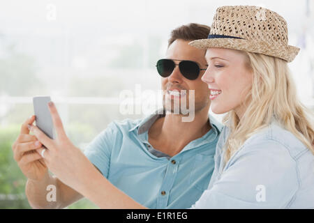 Süßes Paar sitzen im Café Smartphone betrachten Stockfoto
