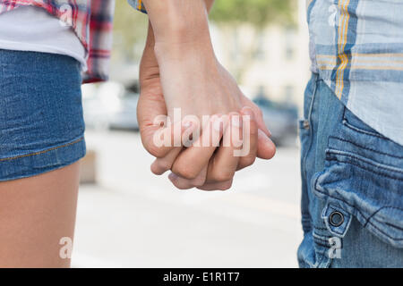 Paar in Check-Hemden und Jeans, die Hand in Hand Stockfoto