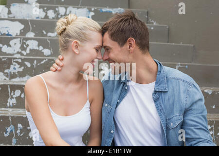 Hippe junge Paar sitzen auf Stufen Lächeln einander an Stockfoto