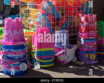 Buntes Spielzeug Eimer für den Verkauf in einem direkt am Strand laden in Filey, Yorkshire Stockfoto