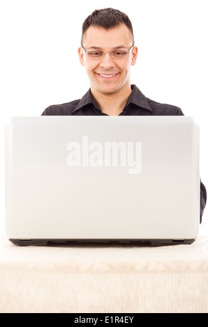 gut aussehend zufrieden lächelnder Mann mit Brille in einem schwarzen Hemd Blick auf laptop Stockfoto