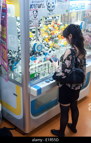 Tokio Japan 2014 - Teenager spielen bei Pachinko-Spiel Stockfoto