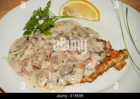 Paniertes Schweineschnitzel in Pilz-Sahne-Sauce (Jaegerschnitzel) erstickt Stockfoto