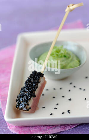 Thunfisch-Sushi mit Sesam, Avocado mit Kräutern und Tabasco Creme Stockfoto