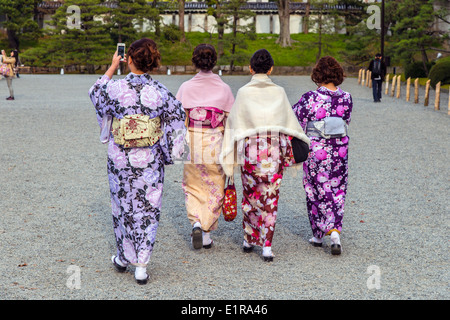 Vier japanische Frauen in traditioneller Tracht, die zu Fuß in Kyoto Imperial Park, Kyoto, Japan Stockfoto