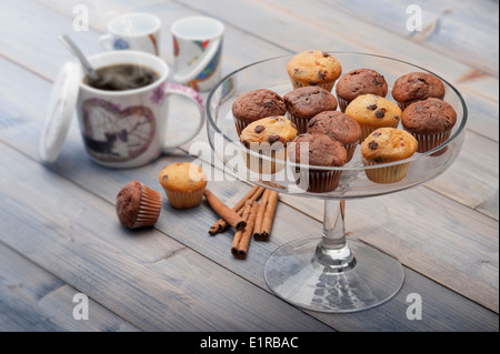 Tablett mit wenig Muffins Abwechslung auf Holztisch mit Tasse Kaffee Stockfoto