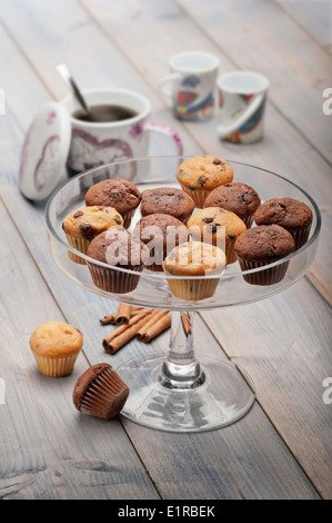 Tablett mit wenig Muffins Abwechslung auf Holztisch mit Tasse Kaffee Stockfoto