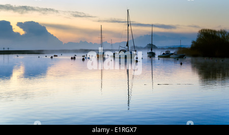 Ein nebliger Sonnenaufgang über Boote vertäut am Kai in Christchurch in Dorset Stockfoto