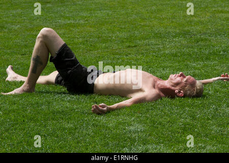 London, UK. 9. Juni 2014. Ein Mann Sonnenbaden auf dem Rasen, wie das warme Wetter und der Sommer endlich Credit kommen: Amer Ghazzal/Alamy Live-Nachrichten Stockfoto