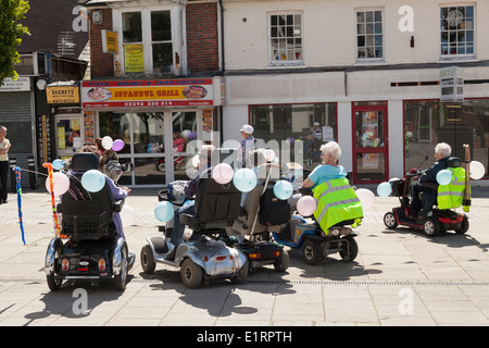 Gruppe von Menschen tun ein Charity-Volkslauf zugunsten von Southampton Krankenhaus auf dekoriert Mobilität Roller. Stockfoto