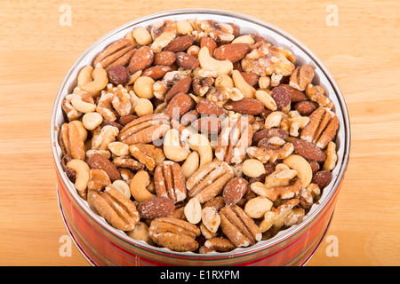 Deluxe mixed Nuts in der runden Dose auf einem Holztisch Stockfoto