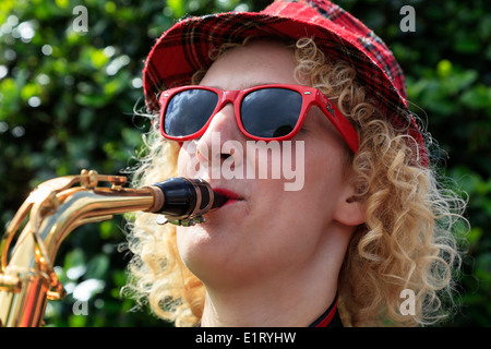 Frau trägt einen Tartan hat und Red Ray Ban Sonnenbrille Saxophon an der West End Street Festival, Glasgow, Schottland, Großbritannien Stockfoto