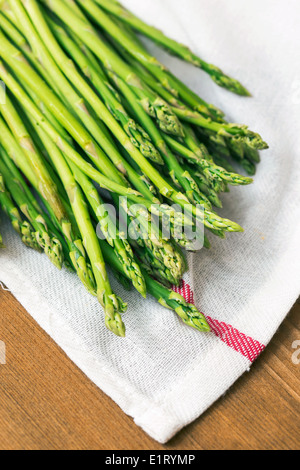 Grüner Spargel auf ein weißes Handtuch auf dem Tisch Sprossen Stockfoto