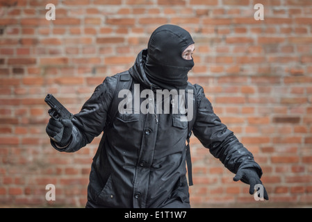 Mann mit Maske mit Pistole Stockfoto