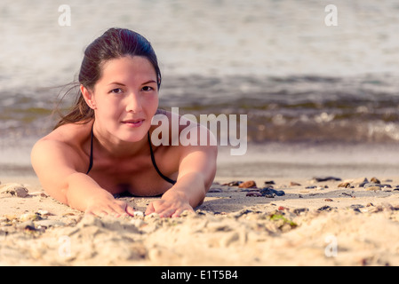 Schöne weibliche Modell Verlegung in Sand am Strand. Stockfoto