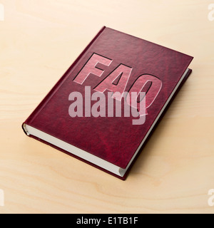 FAQ-Buch. Häufig gestellte Fragen oder Führer auf der Tabelle gedruckt. Stockfoto