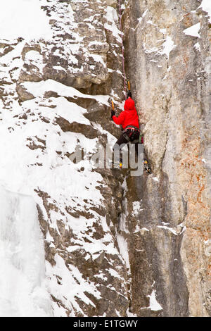 Junger Mann klettert eine Mischung aus Eis und Fels und Eisklettern im Banff National Park in der Nähe von Banff, Alberta, Kanada. Stockfoto
