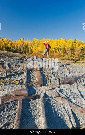 Herbst, Wanderer auf präkambrischen Schild Felsen entlang des Winnipeg River, in der Nähe von Seven Sisters, Manitoba, Kanada Stockfoto