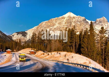 Schulbus unterwegs vor Mount Lawrence Grassi, Canmore, Alberta, Kanada Stockfoto